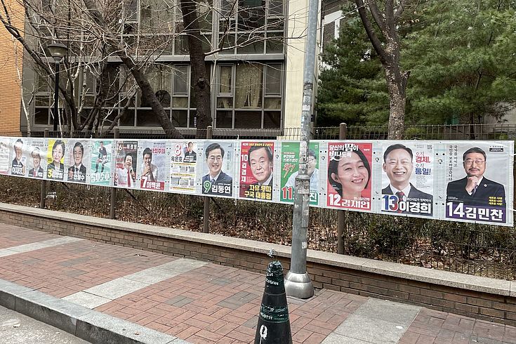 Das Geländer eines Gehsteiges ist dicht behängt mit Plakaten der 14 Kandidaten für die Präsidentschaftswahlen in Korea.